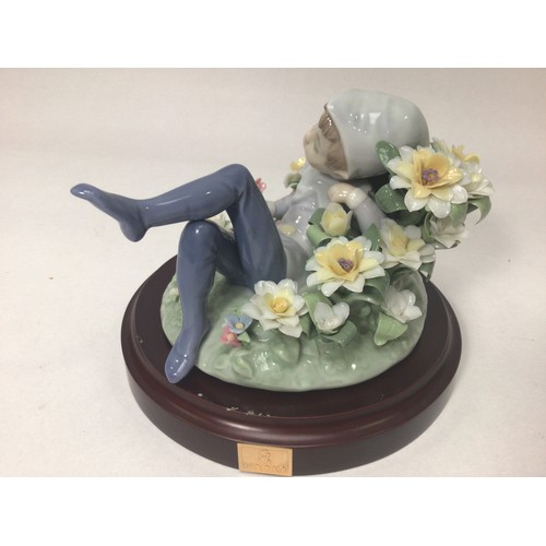 49 - A Lladro porcelain figure of a recumbent leprechaun amongst flowers, ‘Leprechaun No. 1721’, designed... 