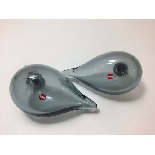 104 - A pair of Oiva Toikka for Iittala studio glass birds, both clear grey with black heads, both with et... 