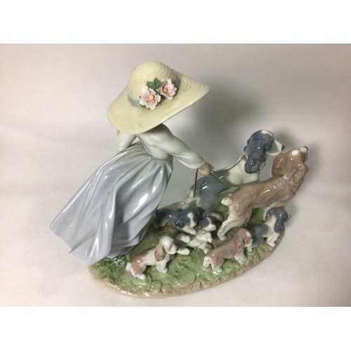 114 - A Lladro porcelain figure group of a young girl walking two spaniels with five puppies in tow, ‘Pupp... 