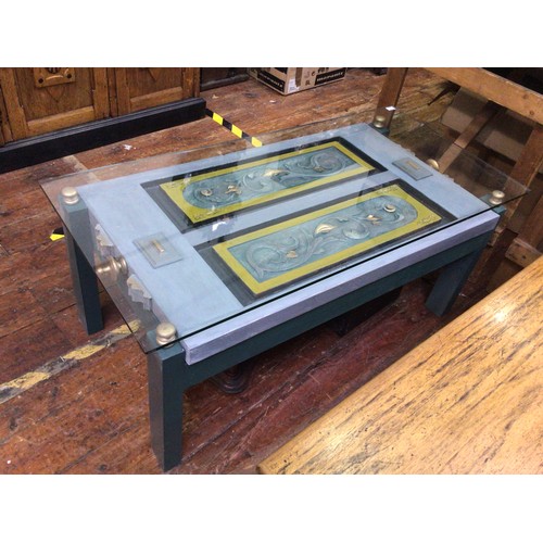 422 - A rectangular glass-topped coffee table, the glass supported by a blue, yellow and gilt painted wood... 