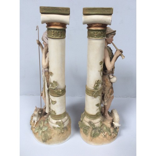 37 - A pair of Royal Dux porcelain figures of a shepherd and shepherdess modelled next to classical Ionic... 