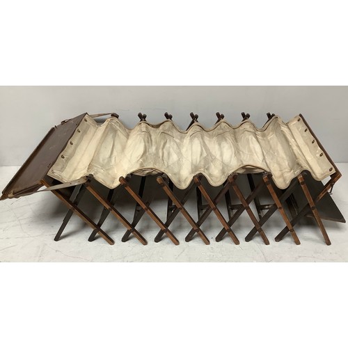 421 - An early 20th century officer's oak and canvas folding concertina campaign bed, 'The Cabinetta' by W... 
