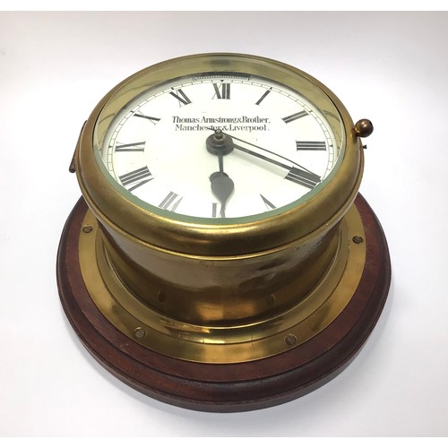 424 - A brass cased ship’s bulkhead clock with white enamel dial, black roman numerals, marked ‘Thomas Arm... 
