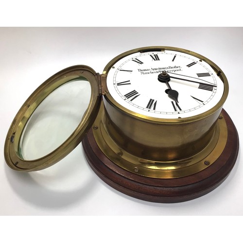 424 - A brass cased ship’s bulkhead clock with white enamel dial, black roman numerals, marked ‘Thomas Arm... 