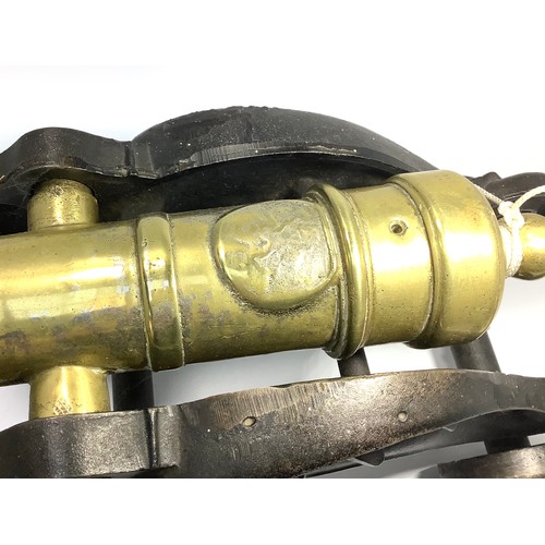 450 - A brass table signalling cannon raised on cast iron carriage modelled as stylised dragons, to four w... 