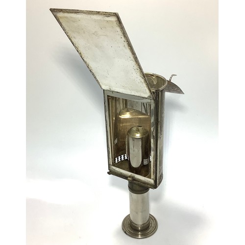 452 - A campaign travel lamp with monogrammed hinged cover, reflective panel and extendable foot, together... 
