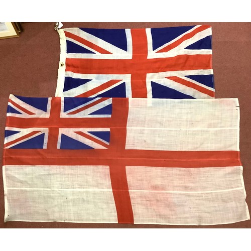 460 - A Royal Navy Ensign flag 130cm x 89cm together with a Union Jack stamped with broad arrow and handwr... 