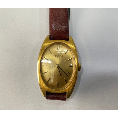 124 - A lady’s yellow metal Tissot wristwatch with oval case, gold coloured dial with batons denoting the ... 