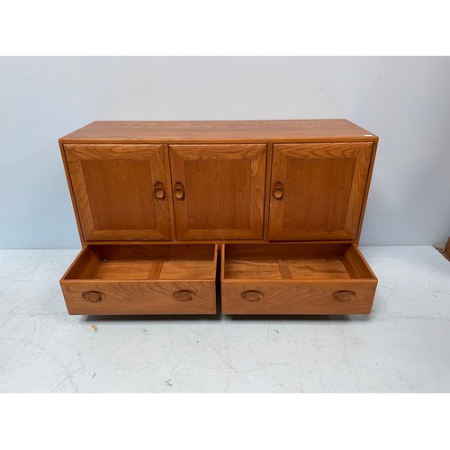 612 - An Ercol Blonde elm Windsor sideboard, with three cupboard doors enclosing shelves, above two drawer... 