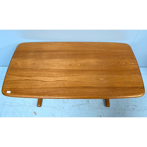 615 - An Ercol blonde elm coffee table, of rectangular form and raised on trestle supports with stretcher,... 