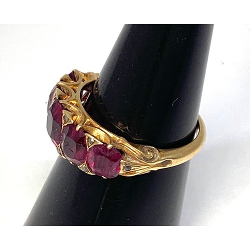 133 - A gold and garnet ring, tests as 18ct, set with five graduated garnets, the largest measuring 7x6mm,... 