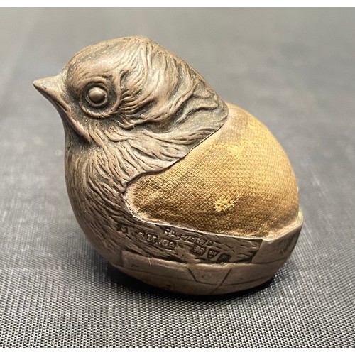 102 - An Edwardian silver pin cushion by Sampson Mordan & Co Ltd, modelled as a bird hatching from an egg,... 