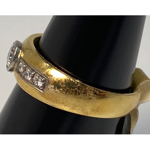 172 - An 18ct yellow gold diamond ring, set with a round brilliant cut diamond to the centre, in a rub-ove... 