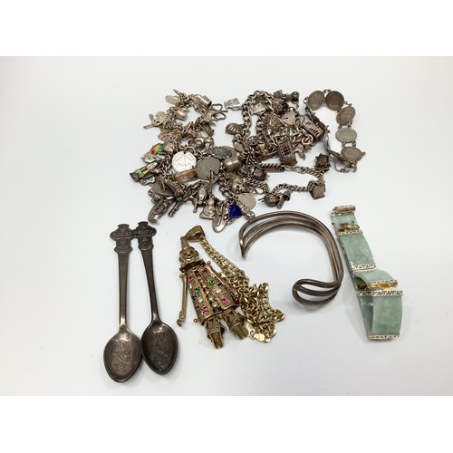 66 - A small collection of assorted silver items comprising various charm bracelets and bangles, propelli... 