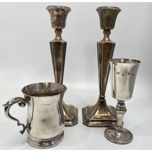 70 - A small collection of silver items comprising a pair of loaded silver candlesticks, 26cm tall, a gob... 