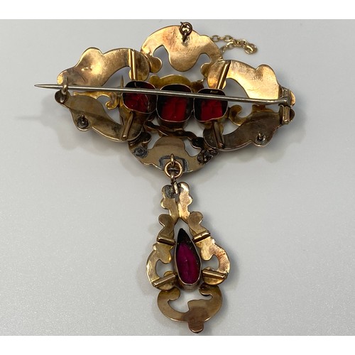 153 - A 9ct gold pierced oval shaped brooch with pendant drop, set with garnet coloured stones, 7 x 5.5cm,... 