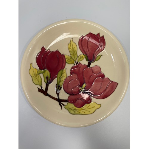 32 - A Moorcroft pottery plate and jug decorated in the Magnolia pattern, designed by Walter Moorcroft, p... 