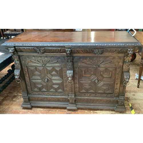 554 - A Victorian carved 'pussy' oak sideboard / cabinet with carved frieze above a pair of drawers with g... 