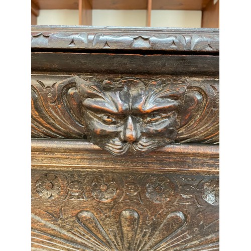 554 - A Victorian carved 'pussy' oak sideboard / cabinet with carved frieze above a pair of drawers with g... 