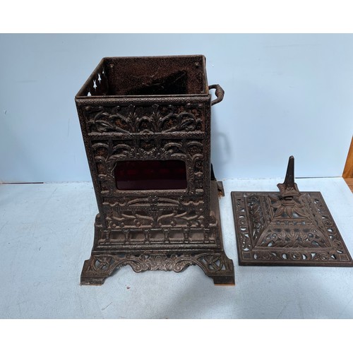 372 - A Rippingilles Patent cast iron stove with red glass panels, twin handles and opposing open sides, 7... 