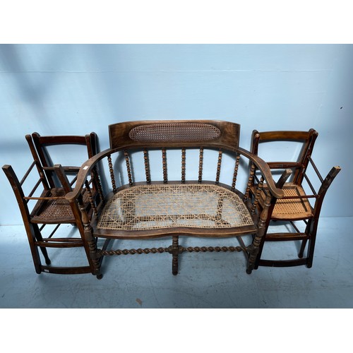 556 - A Victorian oak sofa with rattan back panel, bobbin turned curved back and barley twist stretchers, ... 