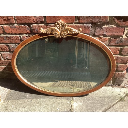 466 - An oval Edwardian inlaid mirror with gold foliate crest and gilt edges, 90cm wide, together with a g... 