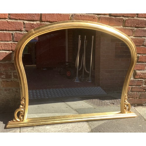 467 - A gilt framed. over-mantel mirror with arched top and shaped sides, 130cm wide