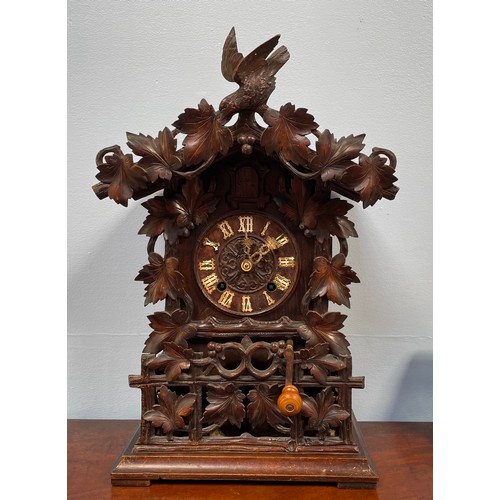 449 - A German black forest carved cuckoo clock with twin fusee movement, ornately carved foliate case wit... 