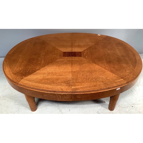 568 - An oak veneered coffee table, of oval form, in two halves with fastenings to underside, beaded top e... 