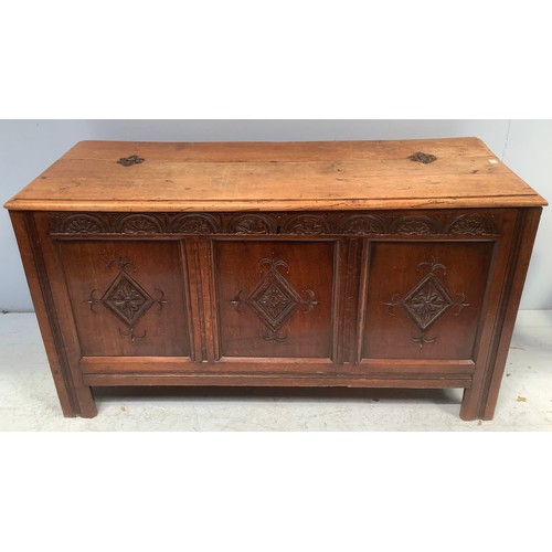 570 - A large stained oak coffer, with three carved panels to front and hinged top enclosing storage space... 