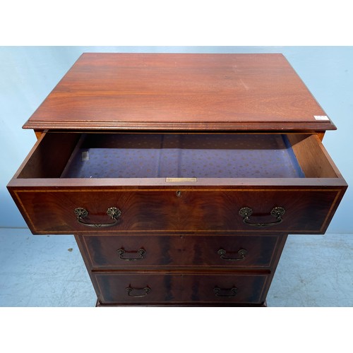 599 - An Edwardian mahogany cross-banded chest of four long graduated drawers with brass handles, raised o... 