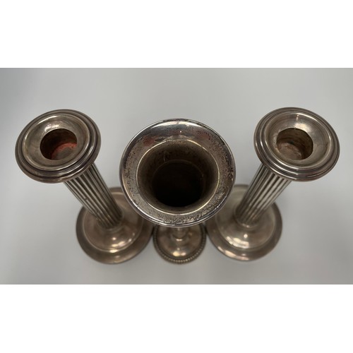 111 - A pair of silver candlesticks with reeded columns and loaded circular bases, 18cm high, together wit... 