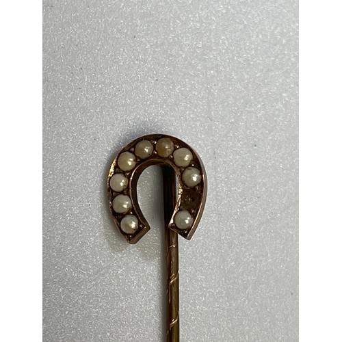 231 - A yellow metal (tests as 9ct gold) tie pin with circular top set with seed pearls and a blue/green s... 