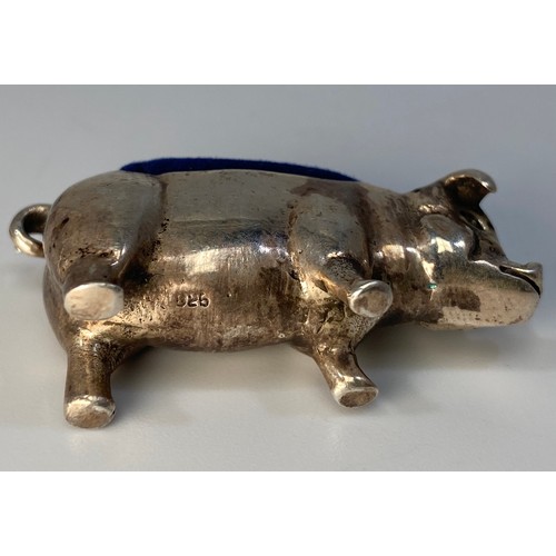 84 - A silver pin cushion modelled as a pig with curled tail, stamped ‘925’, approximately 4cm long