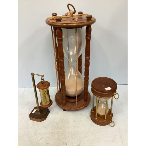 379 - A very large hourglass sand timer in mahogany frame with circular top and bottom, supported by four ... 