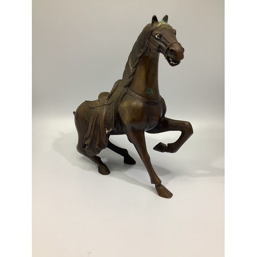 538 - A Chinese bronze figure of a Tang horse, rising from a recumbent posture, 30cm high