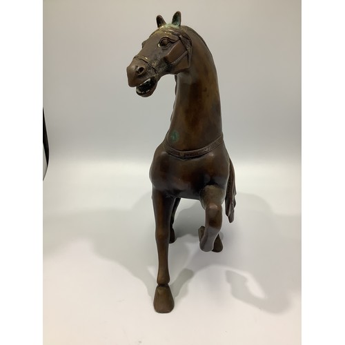 538 - A Chinese bronze figure of a Tang horse, rising from a recumbent posture, 30cm high