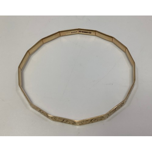 255 - A 9ct gold bangle, with scrolled decoration, gross weight approximately 11.5g