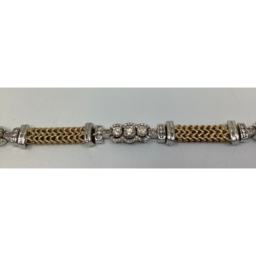 265 - A bi-colour white and yellow metal (tests as 18ct gold or above) tennis bracelet, with three white g... 