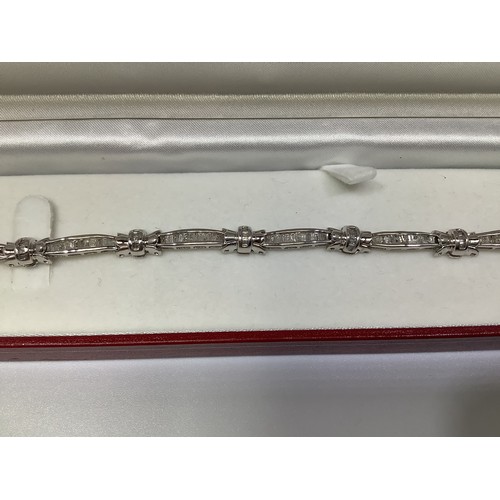 264 - A 14ct white gold and diamond tennis bracelet, set with multiple baguette and tapered baguette diamo... 