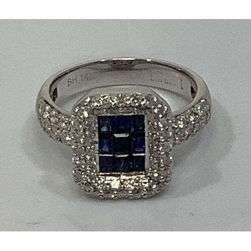 261 - A 14ct white gold ring, the square top centrally set with 9 small baguette cut sapphire coloured gem... 