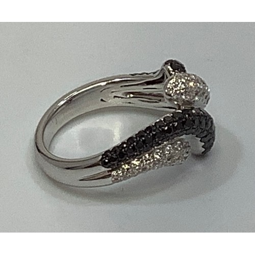 266 - An 18ct white gold crossover style ring, set with multiple small round brilliant cut white and black... 