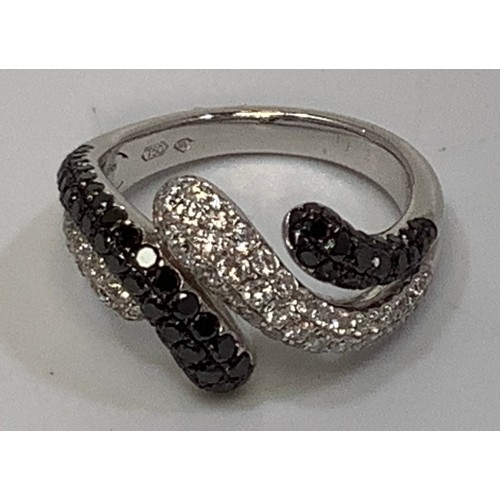 266 - An 18ct white gold crossover style ring, set with multiple small round brilliant cut white and black... 