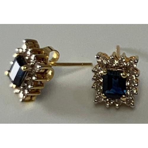 268 - A pair of 18ct gold, sapphire and diamond cluster stud earrings, each centrally four claw set with t... 