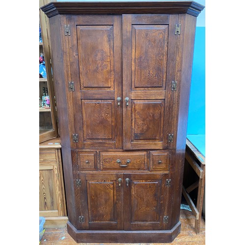 548 - A good quality contemporary Georgian 'style' oak corner cupboard, the two panelled doors enclosing s... 