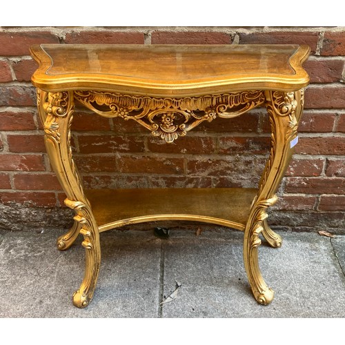 613 - A lacquered gilt-wood console table of serpentine form, with shaped inset glass top, raised on four ... 