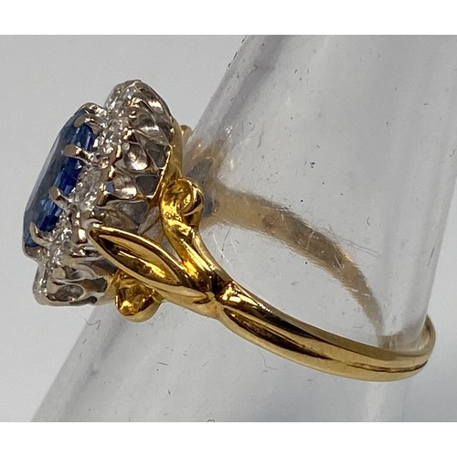 273 - An 18ct gold ring, centrally claw set with an oval faceted sapphire coloured stone, surrounded by te... 