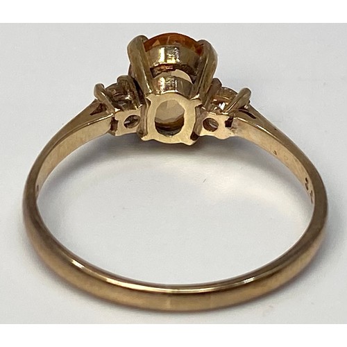 277 - A 9ct gold ring centrally four claw set with an oval faceted citrine coloured stone, flanked by two ... 