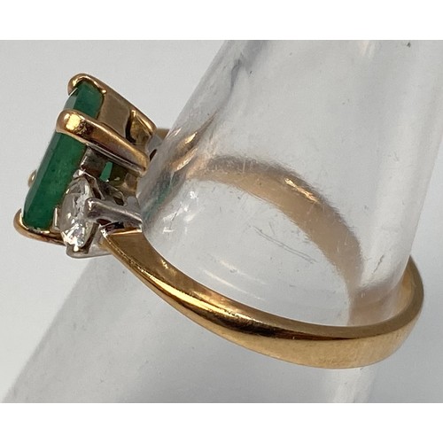 274 - A 9ct gold three stone ring, centrally four claw set with an emerald 'cut' emerald 'coloured' stone,... 