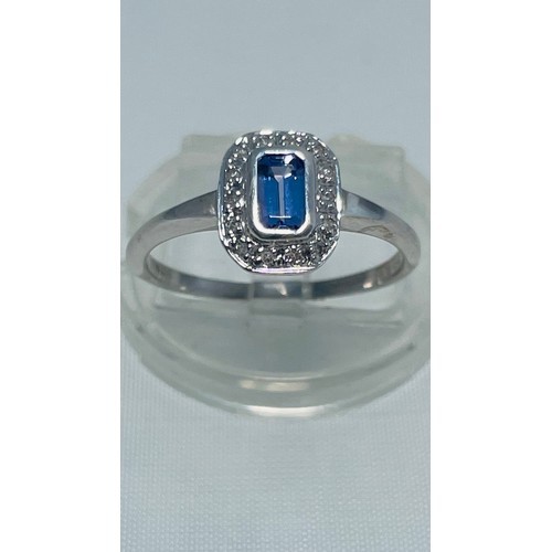 192 - A 9ct white gold dress ring, set with an emerald cut tanzanite to the centre, with small diamonds su... 